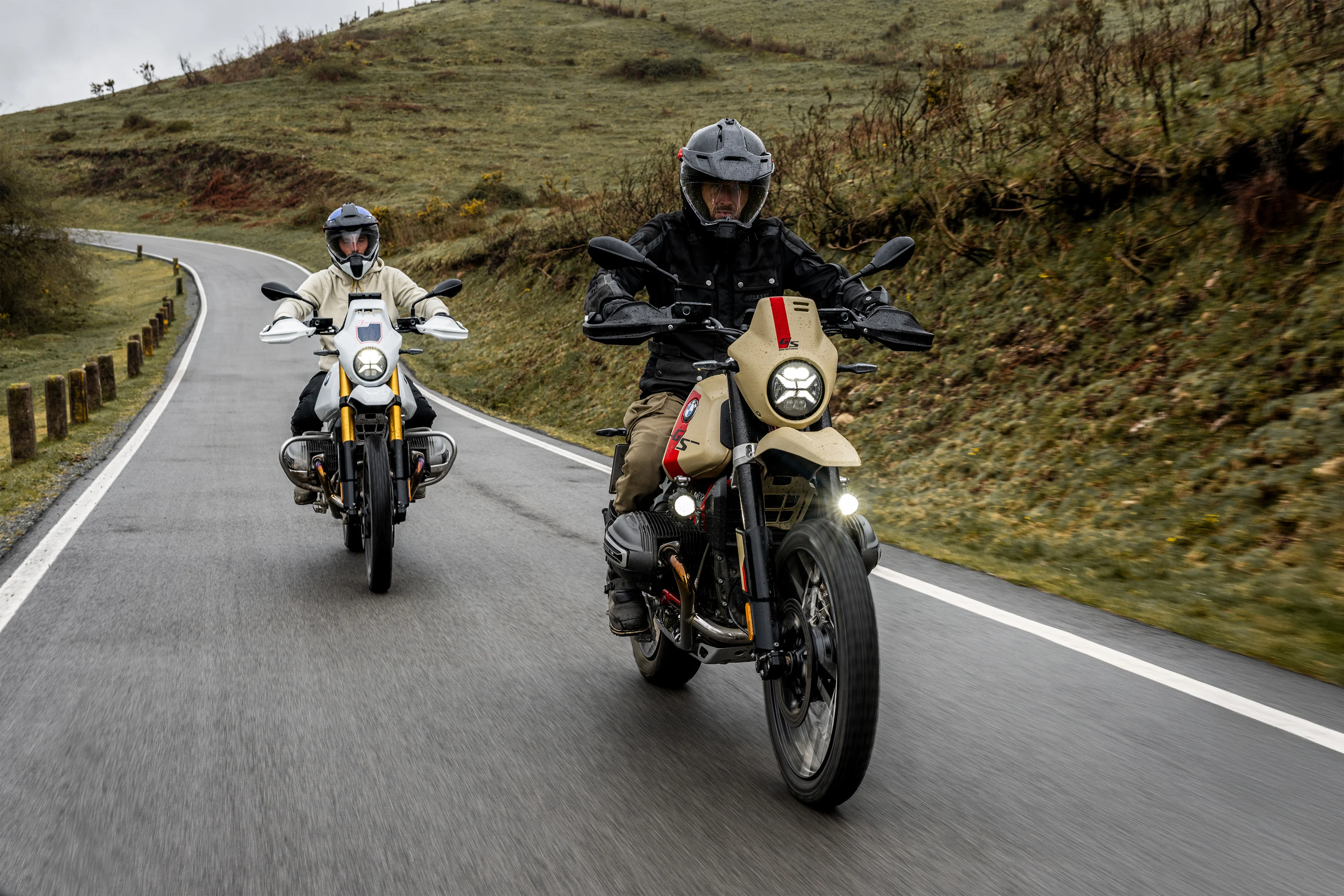 2026 BMW R 12 G/S riders on a mountain road with rolling hills and cloudy sky